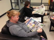 Viele Eltern, wie hier Marion Lange, suchen sich in der großen Schule einen komfortablen Platz aus und vertiefen sich in eine Zeitung, bis die Kinder fertig sind mit dem Unterricht. Foto: Phillip Reeves